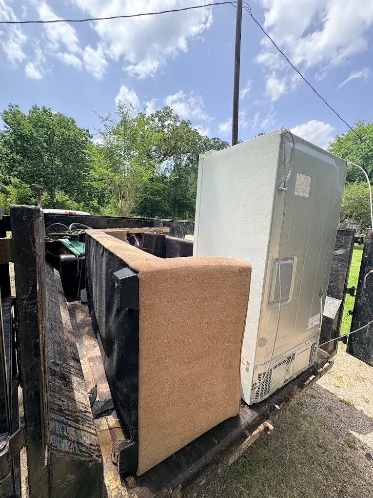 Old refrigerator and couch loaded on the All-In Hauling trailer